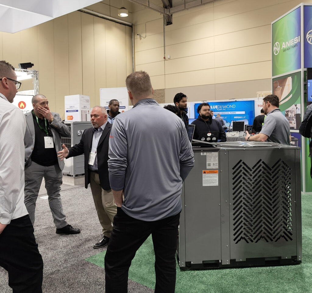 Brad Monaghan, North American Sales Manager at Stone Mountain Technologies, Inc., speaks with Equipco LTD representatives during the CMPX 2024 in Toronto.